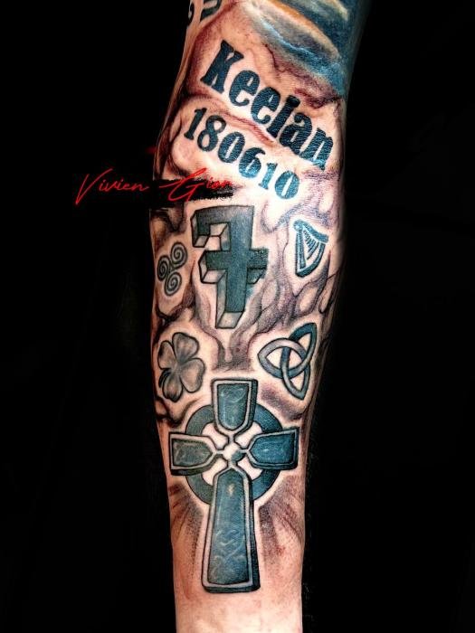 tattoo of jesus cross tattooed on mans leg with other jewelry that represent luck